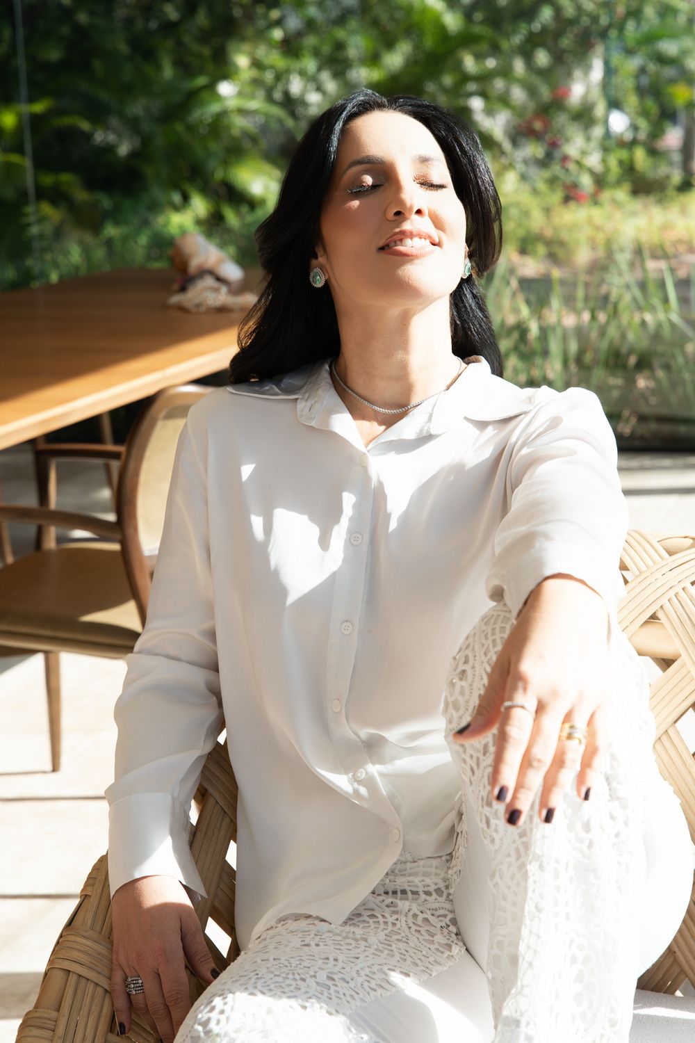 Carolina Barreto relaxada ao sol, de olhos fechados